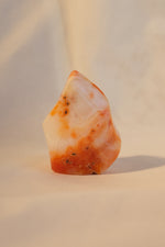 Polished carnelian crystal point on desk