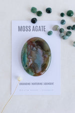 Moss agate stone on a card with descriptive text on a light background