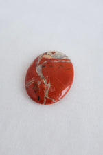 Polished red agate crystal with natural banding