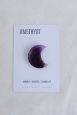 Amethyst crystal on a card with text on a beige background
