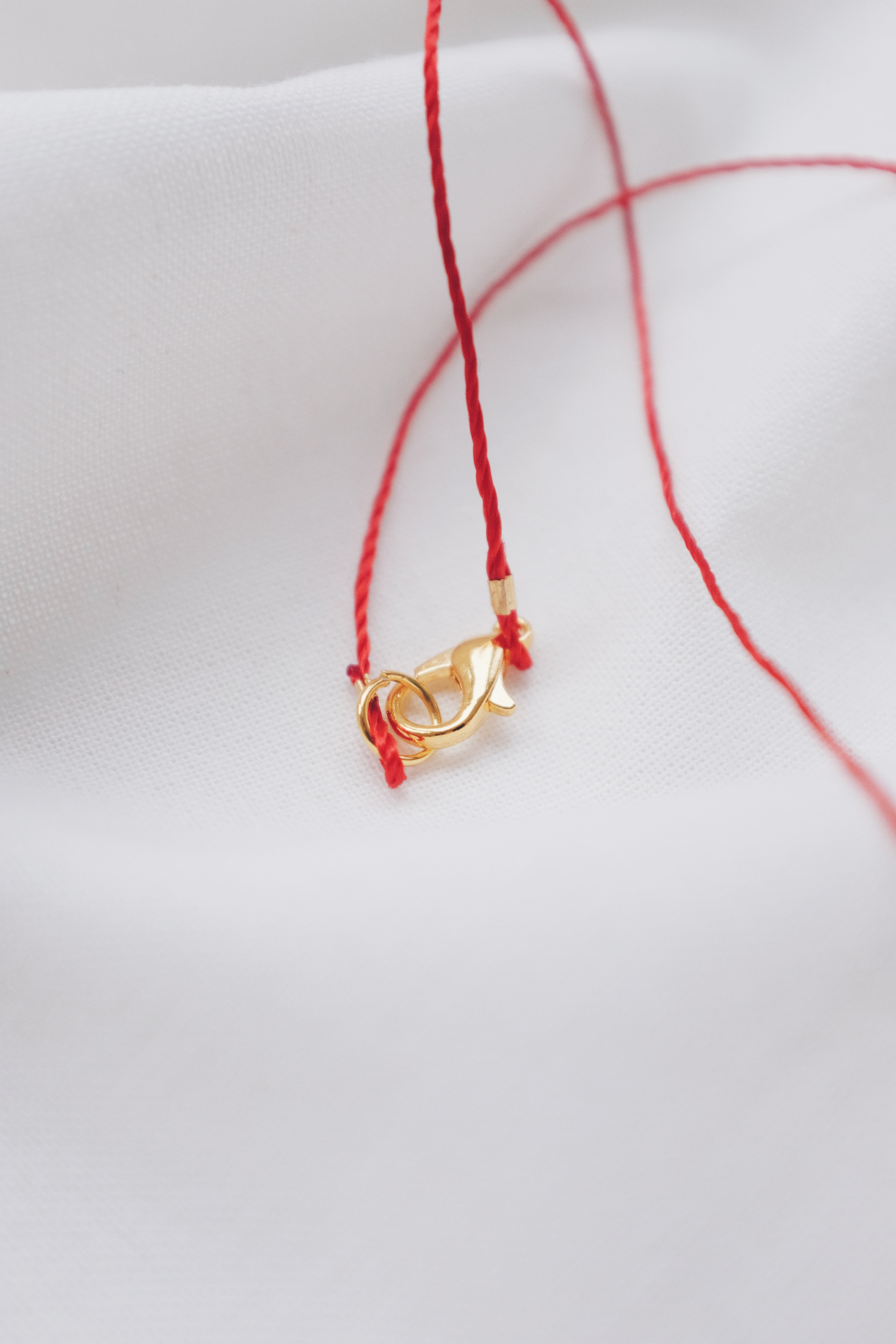 Evil eye pendant necklace on red string, symbolizing protection and warding off negative energy.