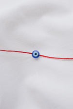 Evil eye pendant necklace on red string, symbolizing protection and warding off negative energy.