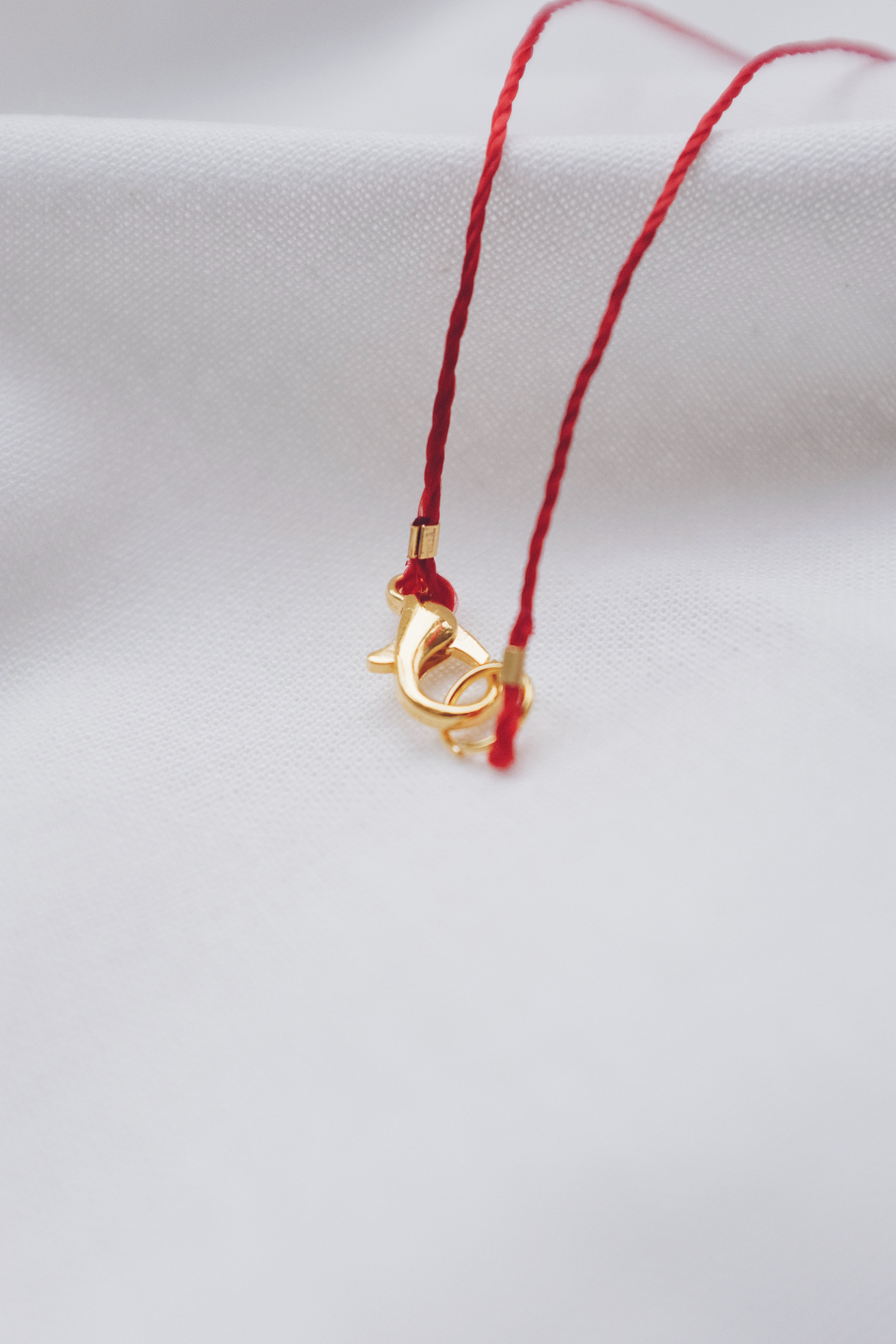 Pearl pendant on a red string necklace, classic and elegant jewelry piece.