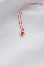 Pearl pendant on a red string necklace, classic and elegant jewelry piece.