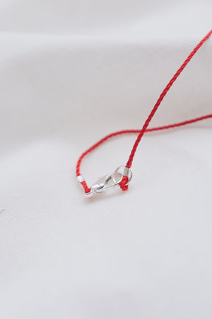 Silver ruby pendant on a red string necklace, elegant and vibrant gemstone jewelry.